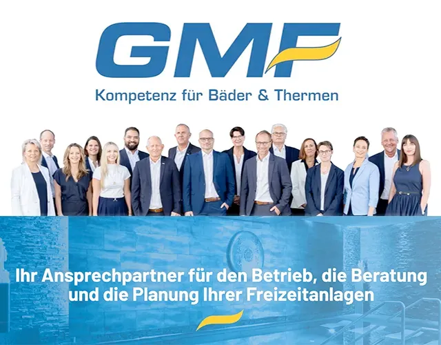 GMF Team Gruppenfoto mit Firmenlogo und Slogan im Hintergrund.